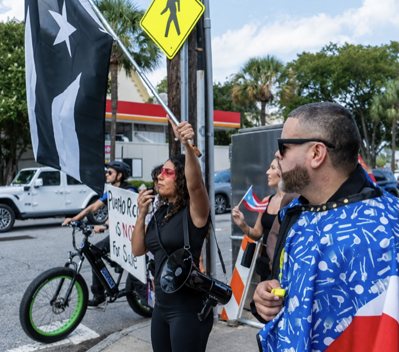 Charleston for Puerto Rico participants carrying a black Puerto Rican flag along the street.